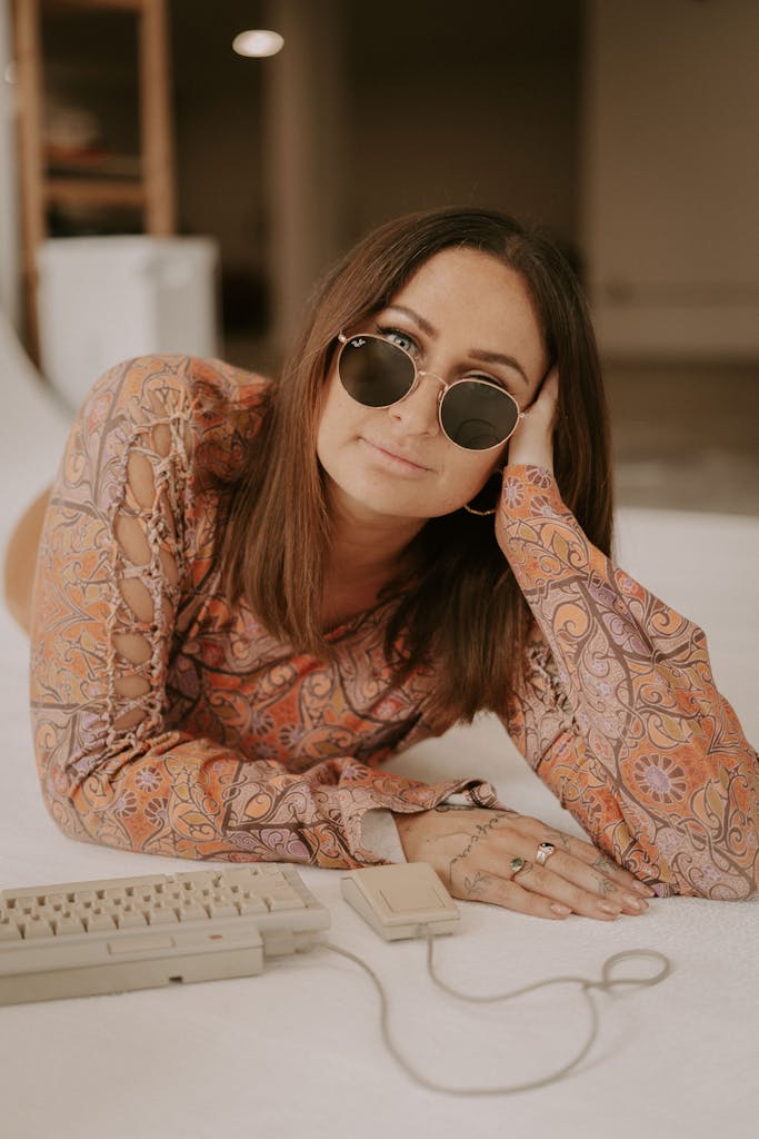 Boho virtual assistant woman poses with vintage computer keyboard in a studio setting.