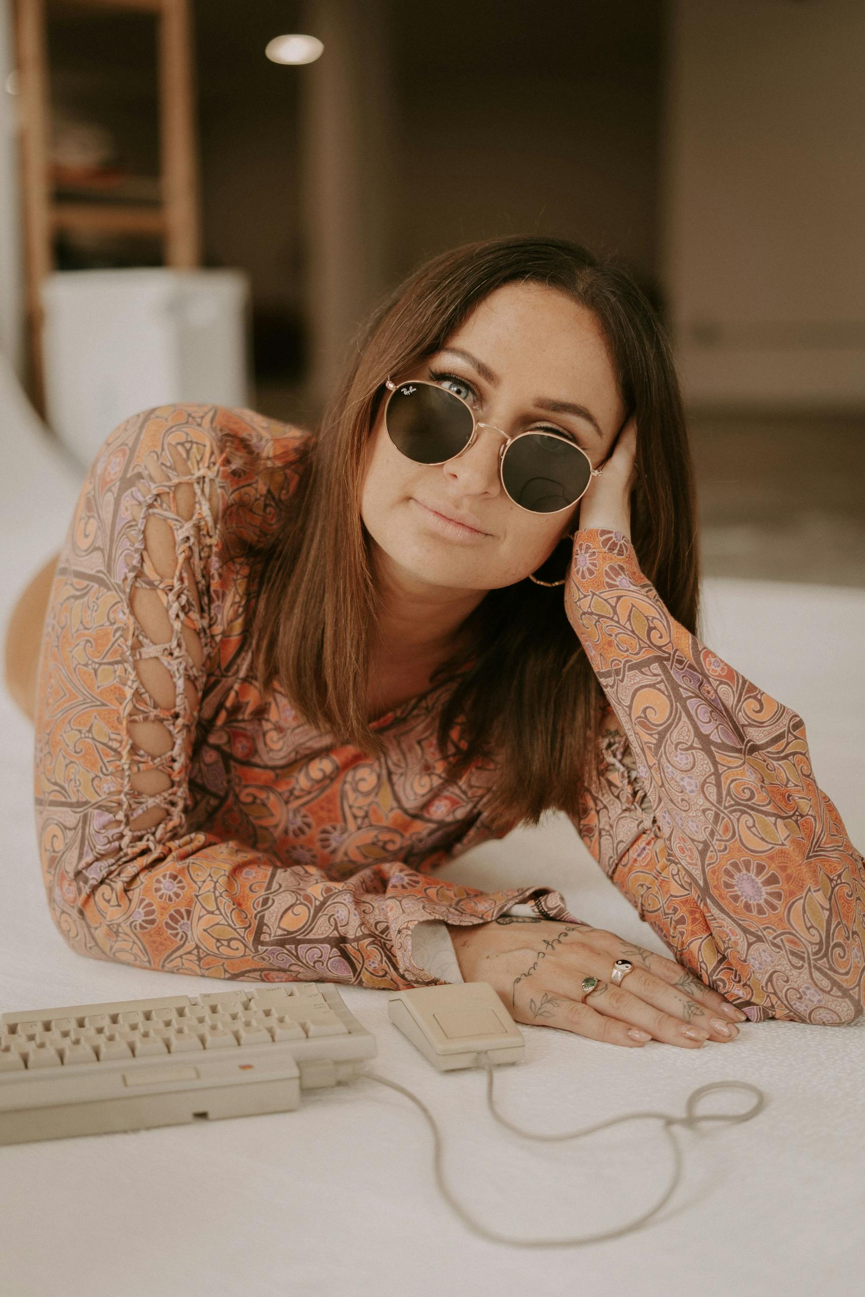 Woman in retro attire poses with vintage computer keyboard ready to join your support team